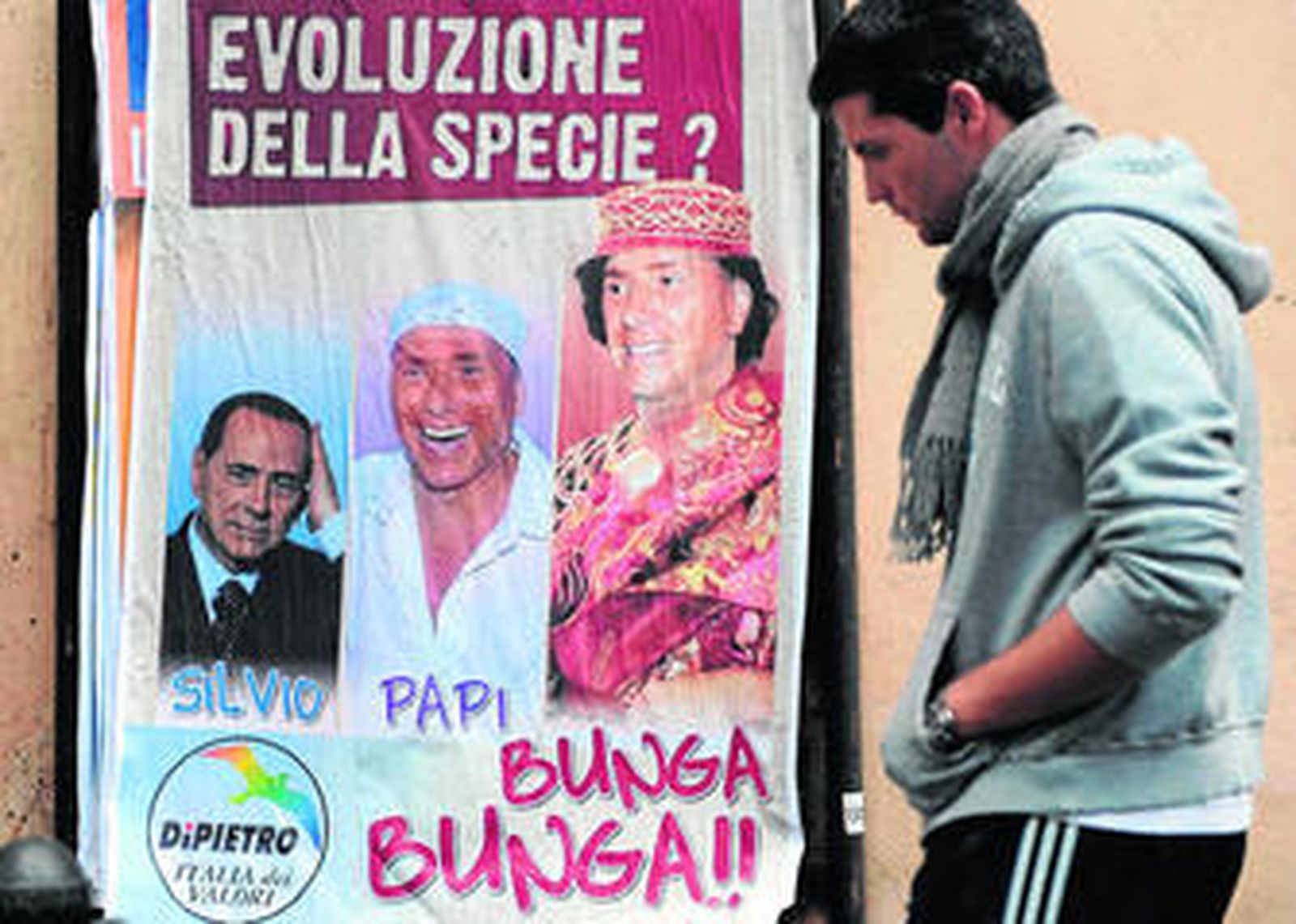 Un joven pasa ante un cartel en el que se ridiculiza al primer ministro italiano