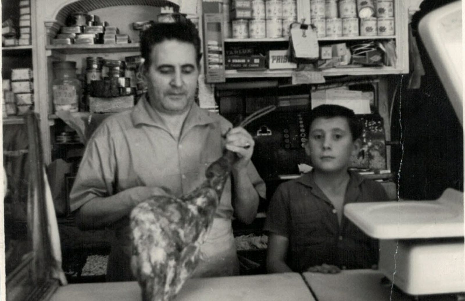 Román Castro corta jamón sin ayuda de caballete en presencia de su hijo Antonio (1961)