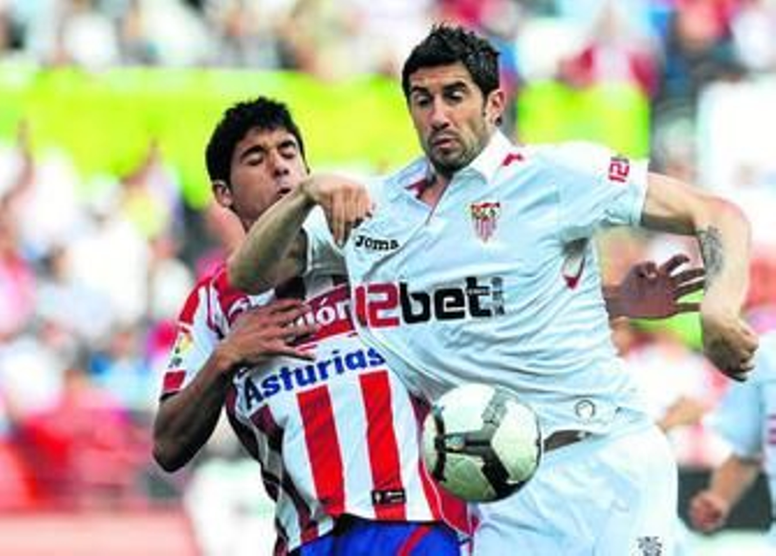 Dragutinovic pugna con un rival en el partido que el Sevilla jugó contra el Sporting la semana pasada.