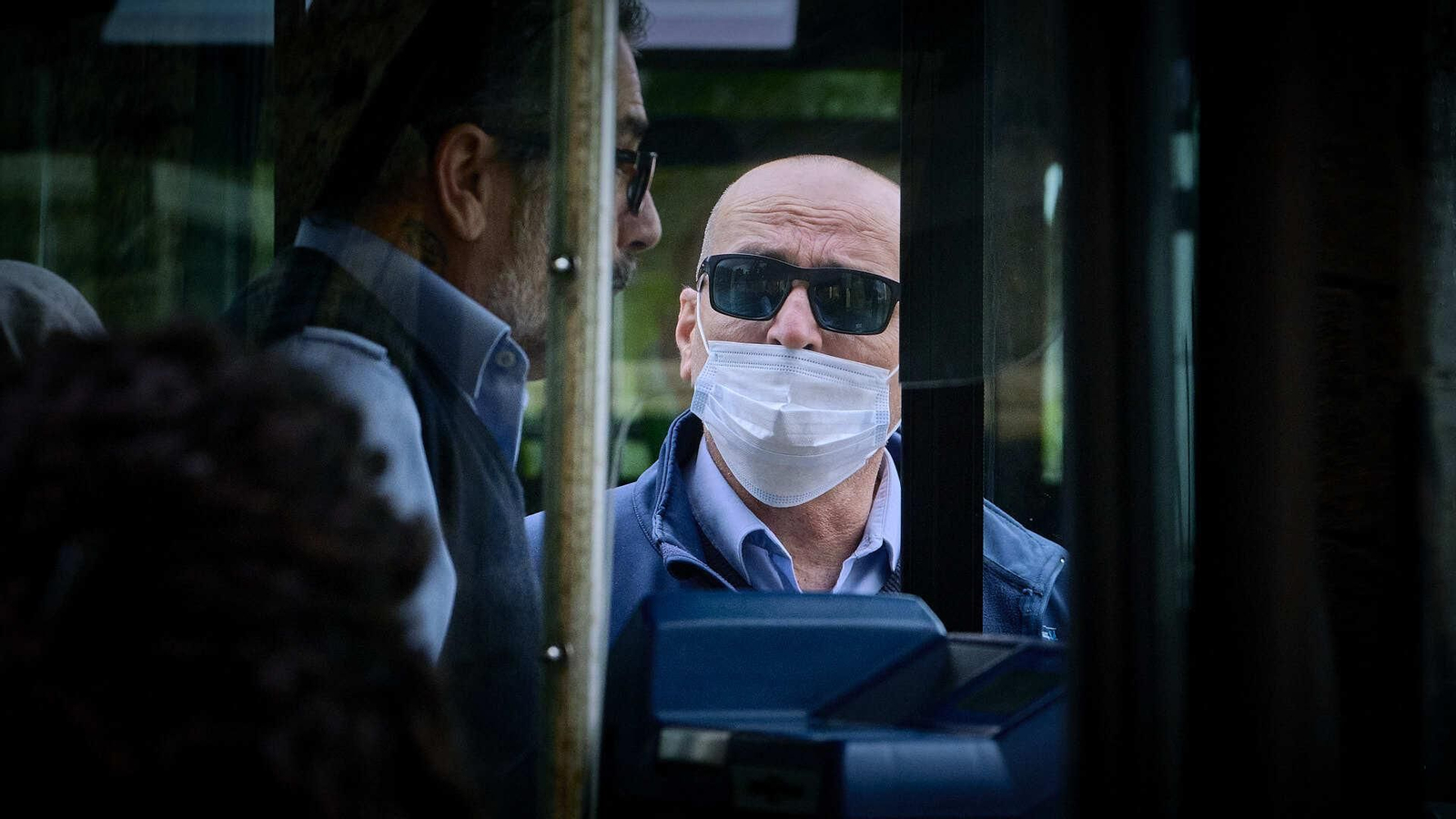 Un empleado de la empresa conversa con el conductor de un autobús