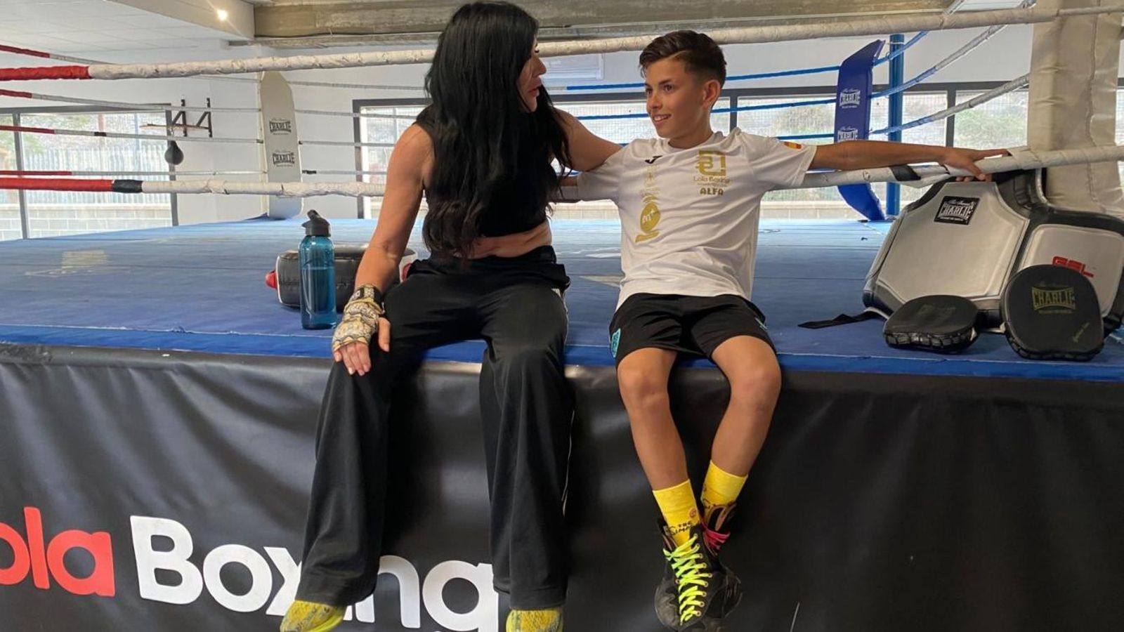 Lola Martínez y Tristán Romero, sentados en el cuadrilátero del Club Lola Boxing.