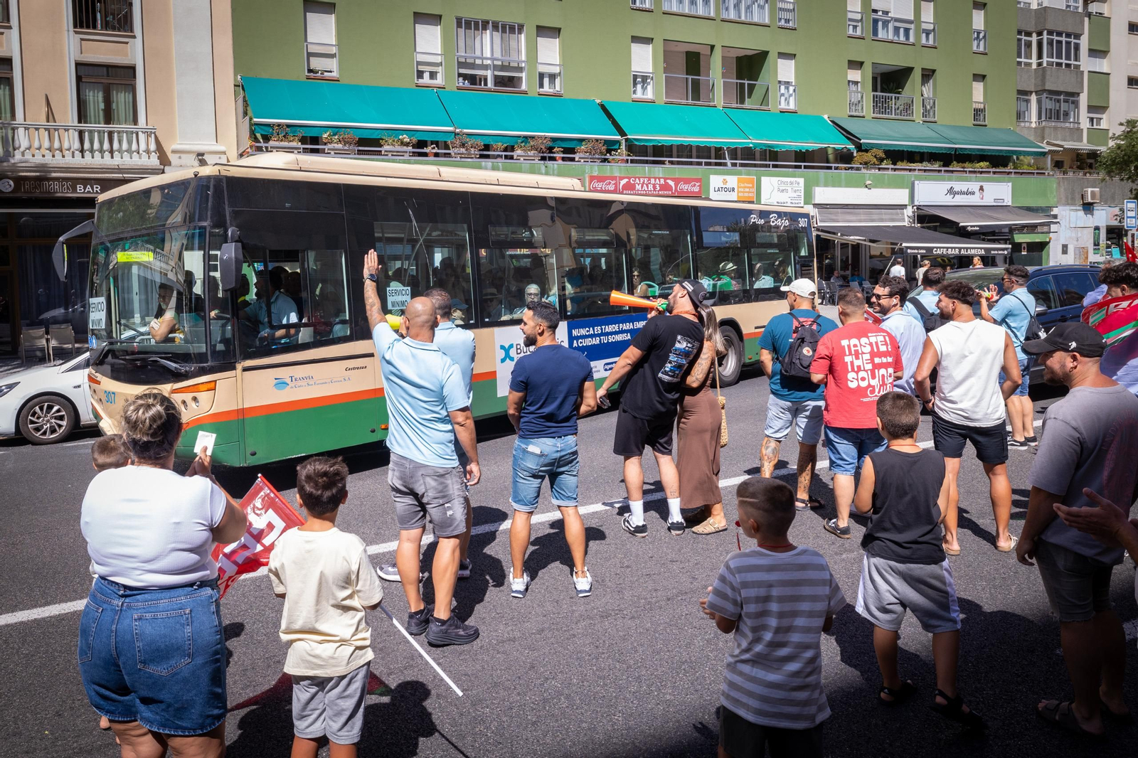 Trabajadores en manifestación por la avenida saludan a un compañero de servicio mínimo