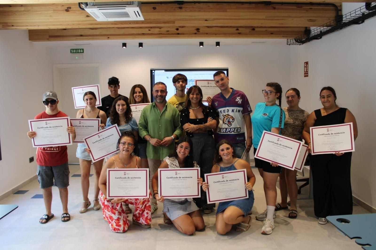 Los jóvenes muestran sus diplomas.