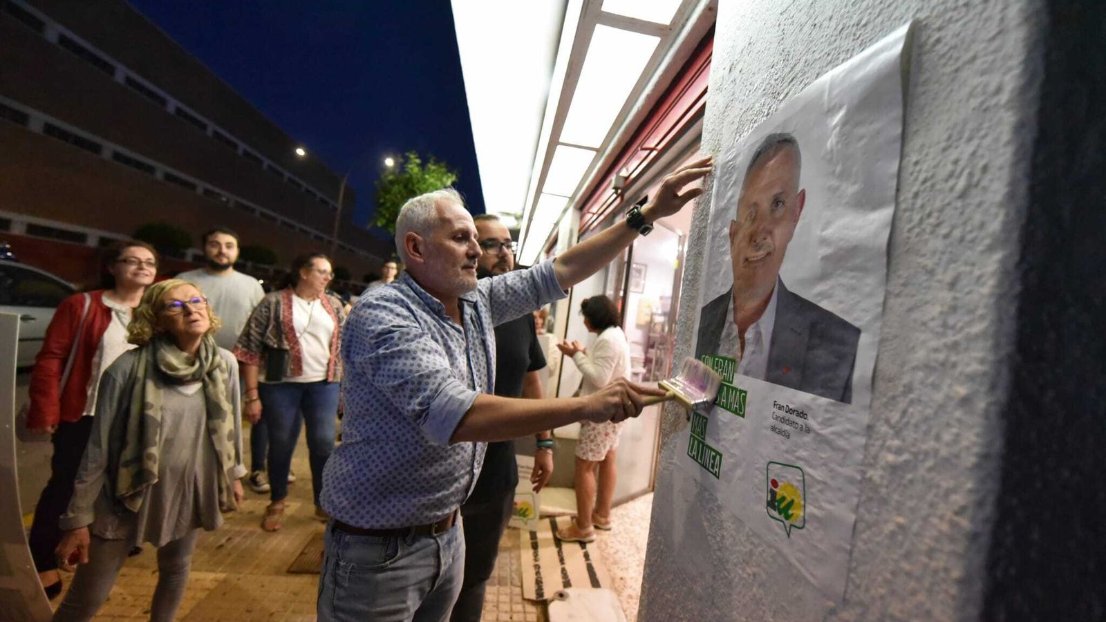 Fran Dorado, candidato de IU en La Línea, pega un cartel.