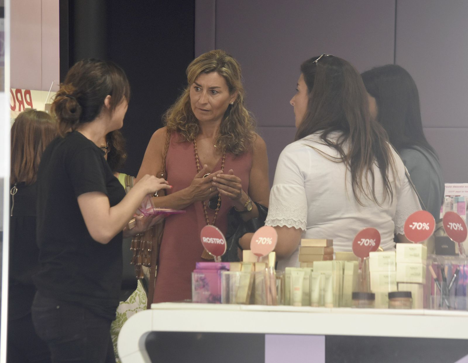 La empleada de una tienda atiende a varias mujeres.
