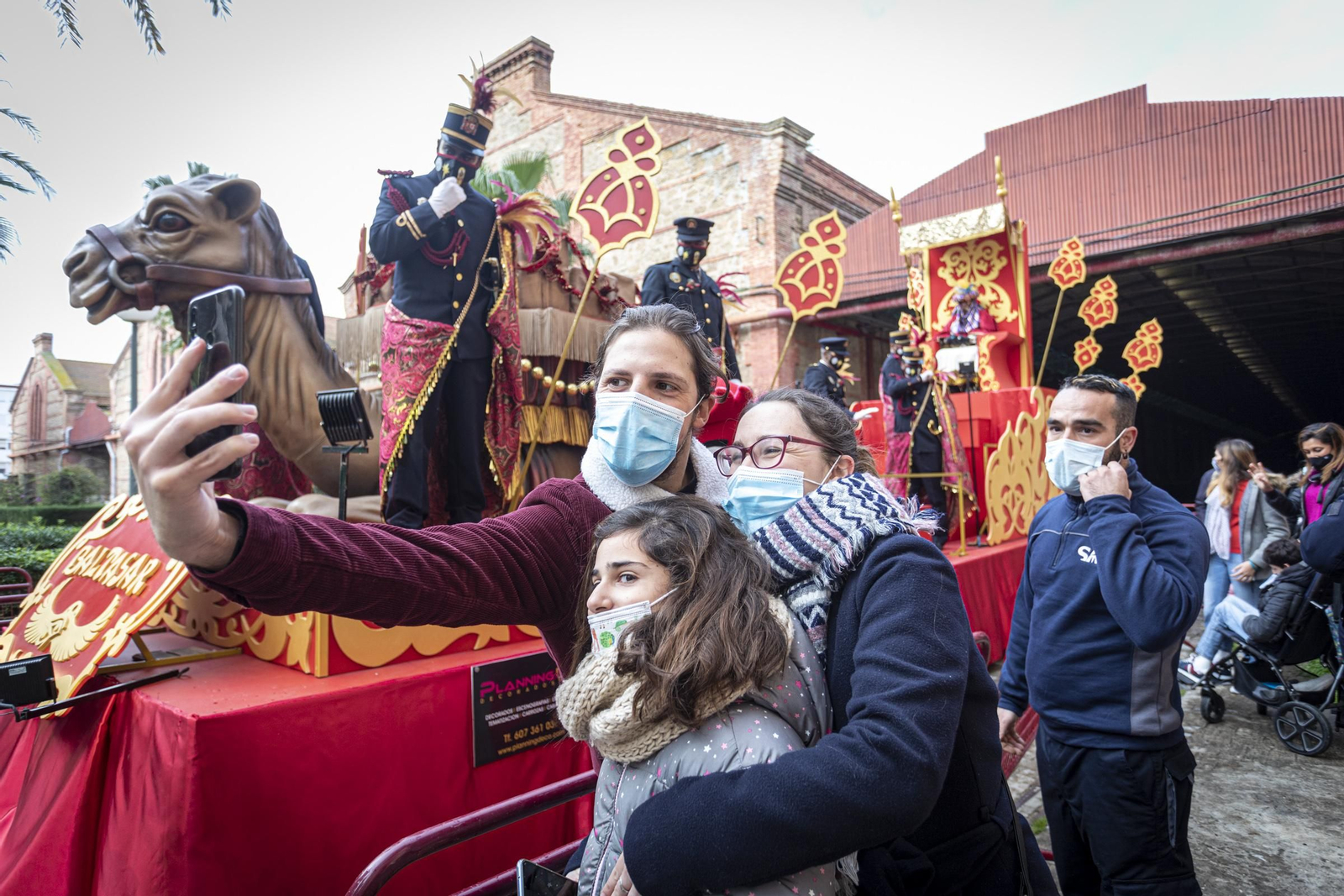 Una familia se hace una foto ante la estática carroza de Baltasar, colocada el 5 de enero de 2021 ante los antiguos depósitos de tabacos.