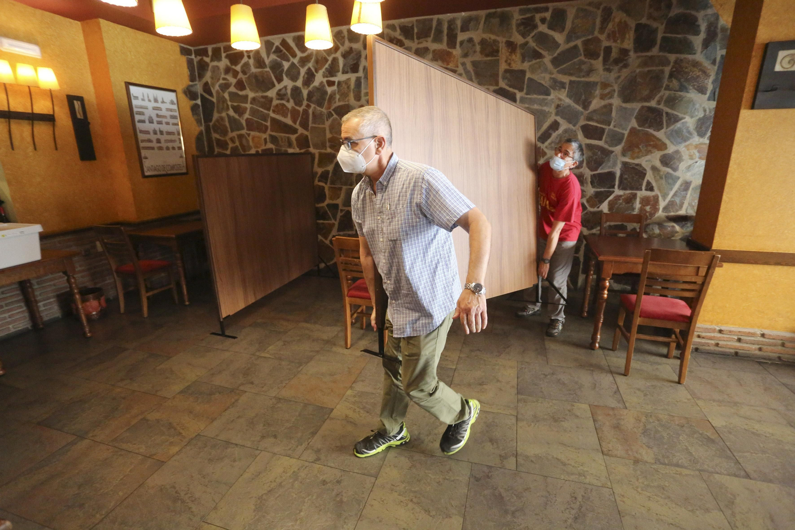 Dos trabajadores del restaurante mueven una de las mamparas.