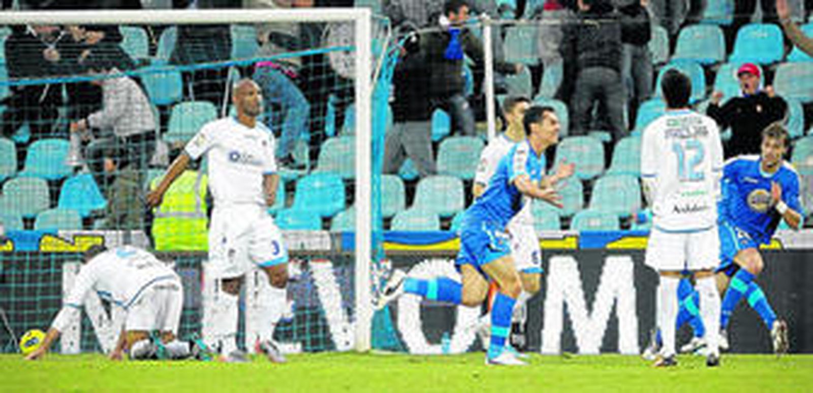 Casquero celebra su tanto ante la mirada rendida de los jugadores del Granada.