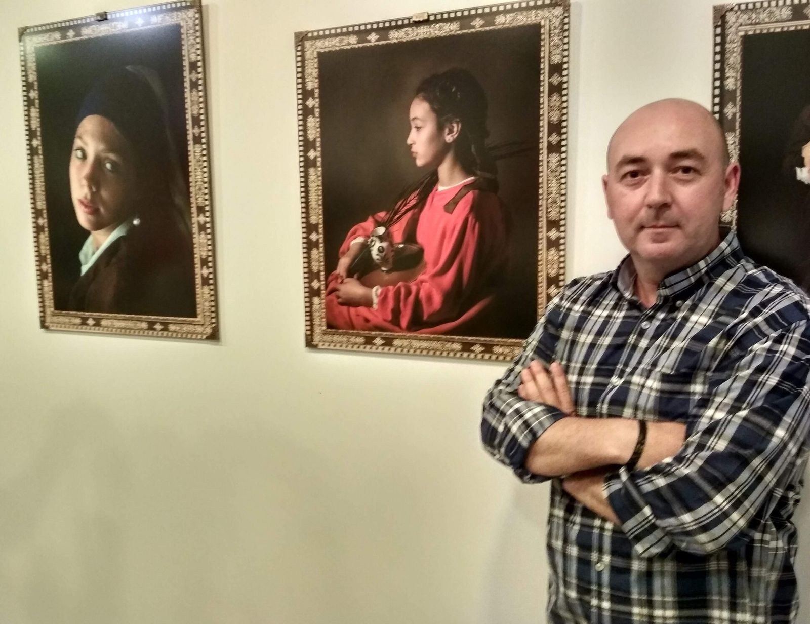 El fotógrafo sanluqueño Óscar Franco, junto a dos de las 17 de las instantáneas que expone estos días en la Parroquia de Santo Domingo.