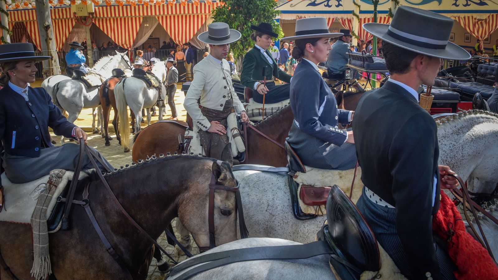 Varios caballistas pasean por las calles principales del real, durante la tarde de ayer.