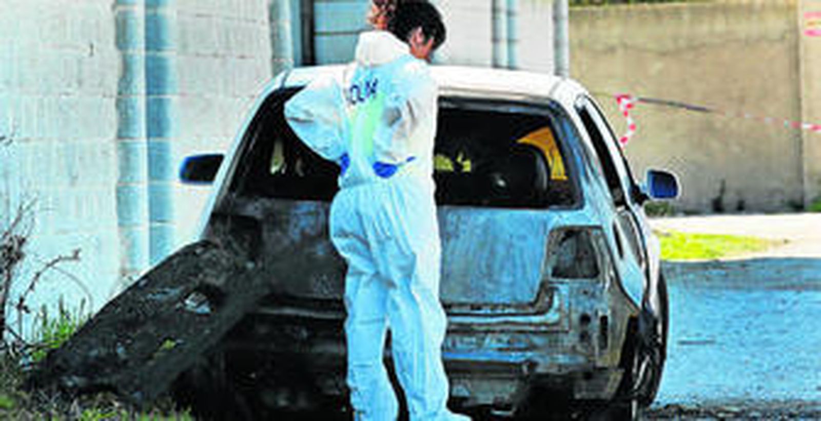 Una agente de la Policía Nacional, junto al coche en cuyo interior aparecía el cadáver de Ángel Rodríguez el pasado jueves, en El Puerto.