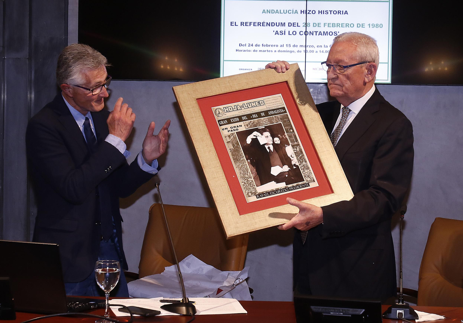 Rafael Rodríguez, presidente de la Asociación de la Prensa, entrega un ejemplar de la Hoja del Lunes del primer día de Andalucía a Rafael Escuredo.
