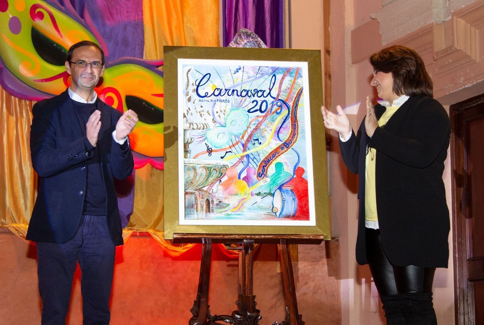 El alcalde mostrando el cartel anunciador junto a su autora en el Auditorio de la Merced.