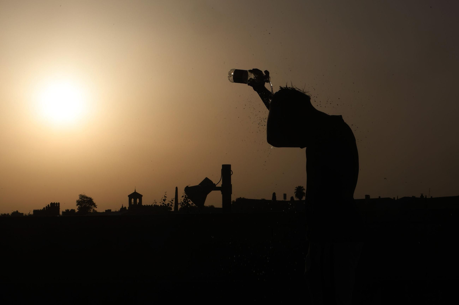 Una persona se refresca al atardecer en una jornada de altas temperaturas en Córdoba.