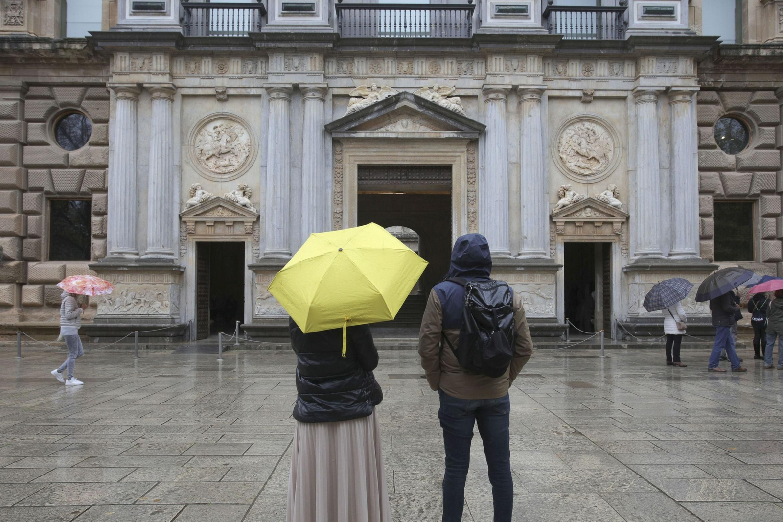 Dos personas frente al Palacio de Carlos V en una imagne de archivo.