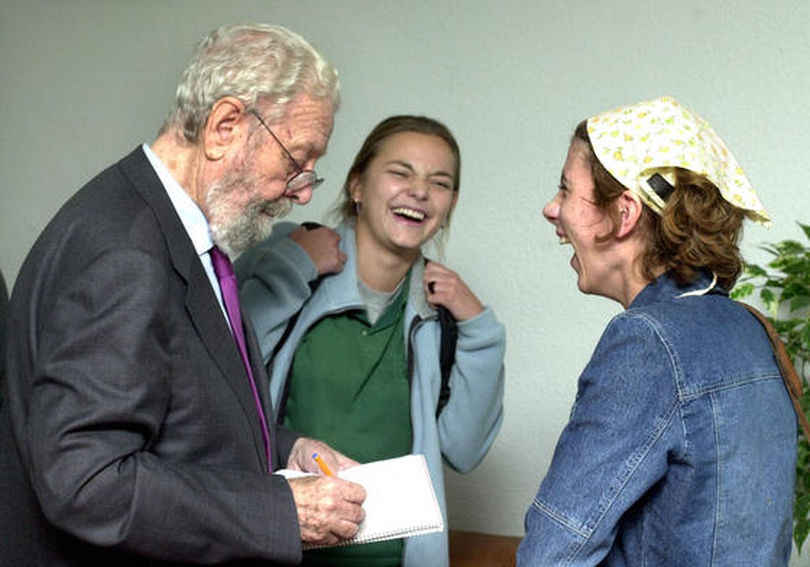 Luis García Berlanga bromea con dos estudiantes de Periodismo al comienzo de una mesa redonda sobre Luis Buñuel celebrada en la Universidad Complutense. / EFE
