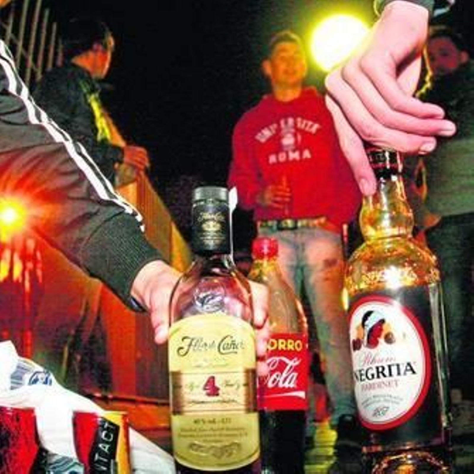 Unos jóvenes hacen 'botellón' en plena calle.