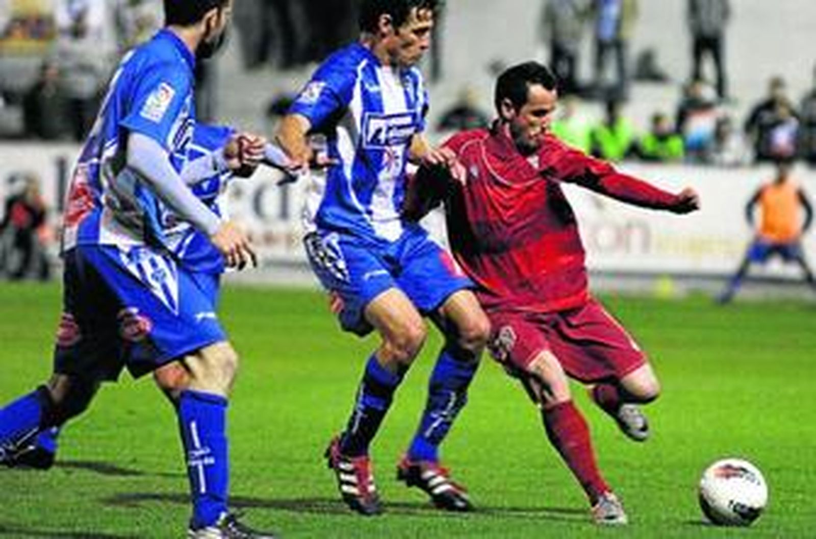López Silva trata de enviar el balón a un compañero ante el acoso de dos jugadores del Alcoyano, ayer en El Collao.