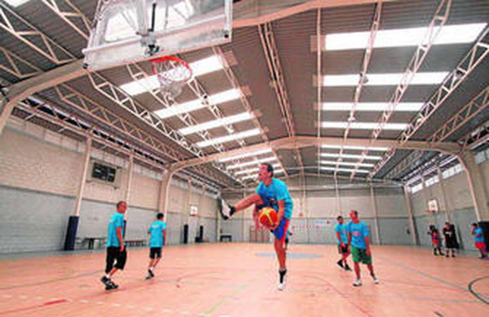 Un grupo de chavales del Club deportivo y cultural Huracán juegan al baloncesto, en el polideportivo Manuel Marín.