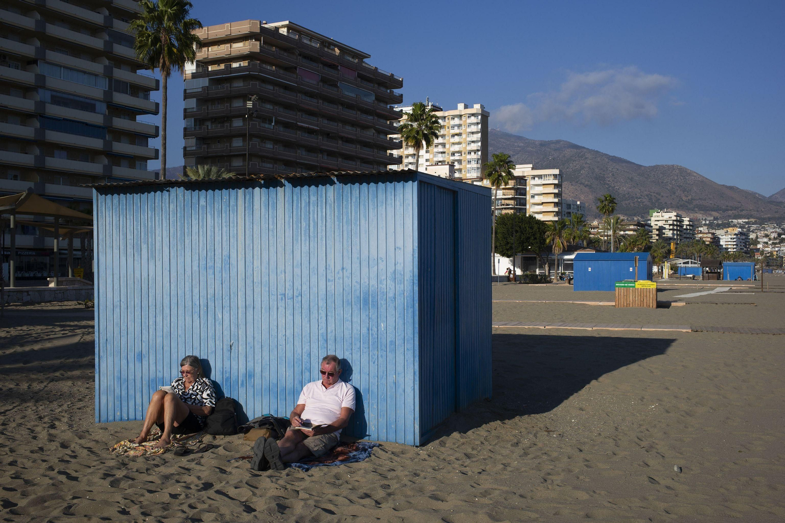 Dos extranjeros toman el sol en la playa de los Boliches, en Fuengirola.