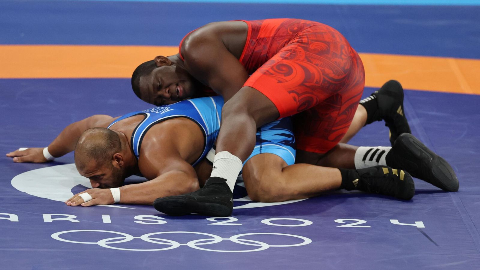 El luchador cubano Mijain López (rojo) ante el chileno Yasmani Acosta en la final de lucha grecorromana, 130 kg masculino.