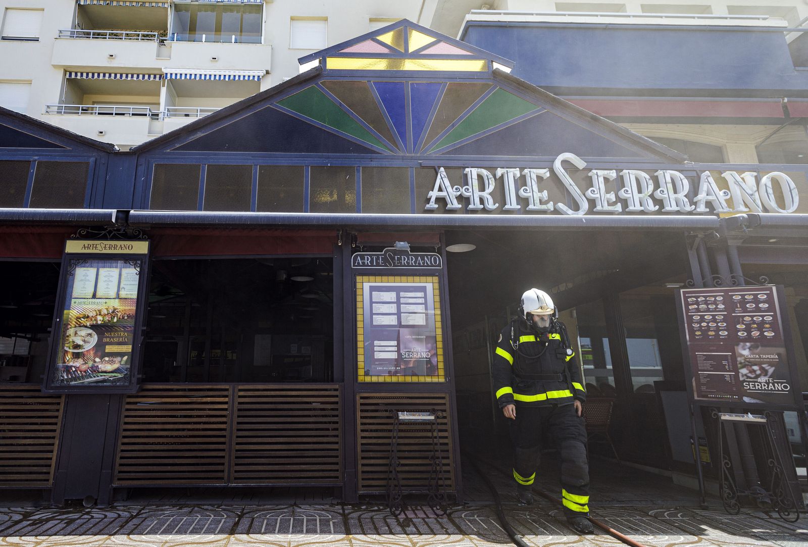 Un bombero saliendo del restaurante Arte Serrano tras extinguir el incendio.