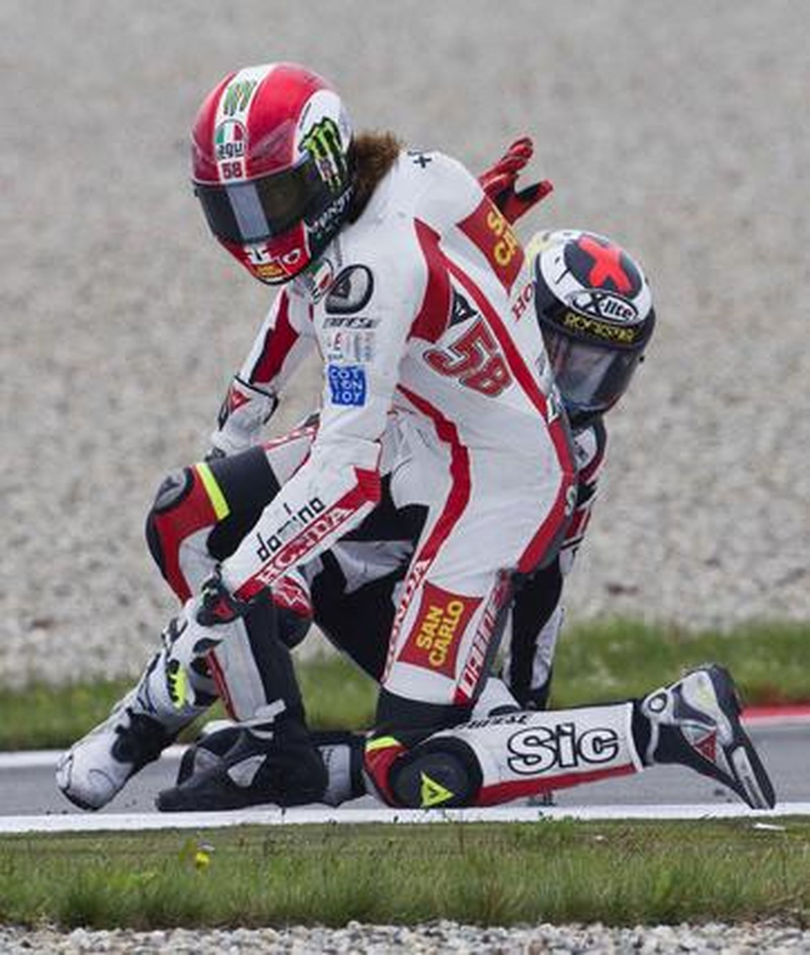 Marco Simoncelli se cayó y se llevó por delante a Jorge Lorenzo.

Foto: Reuters