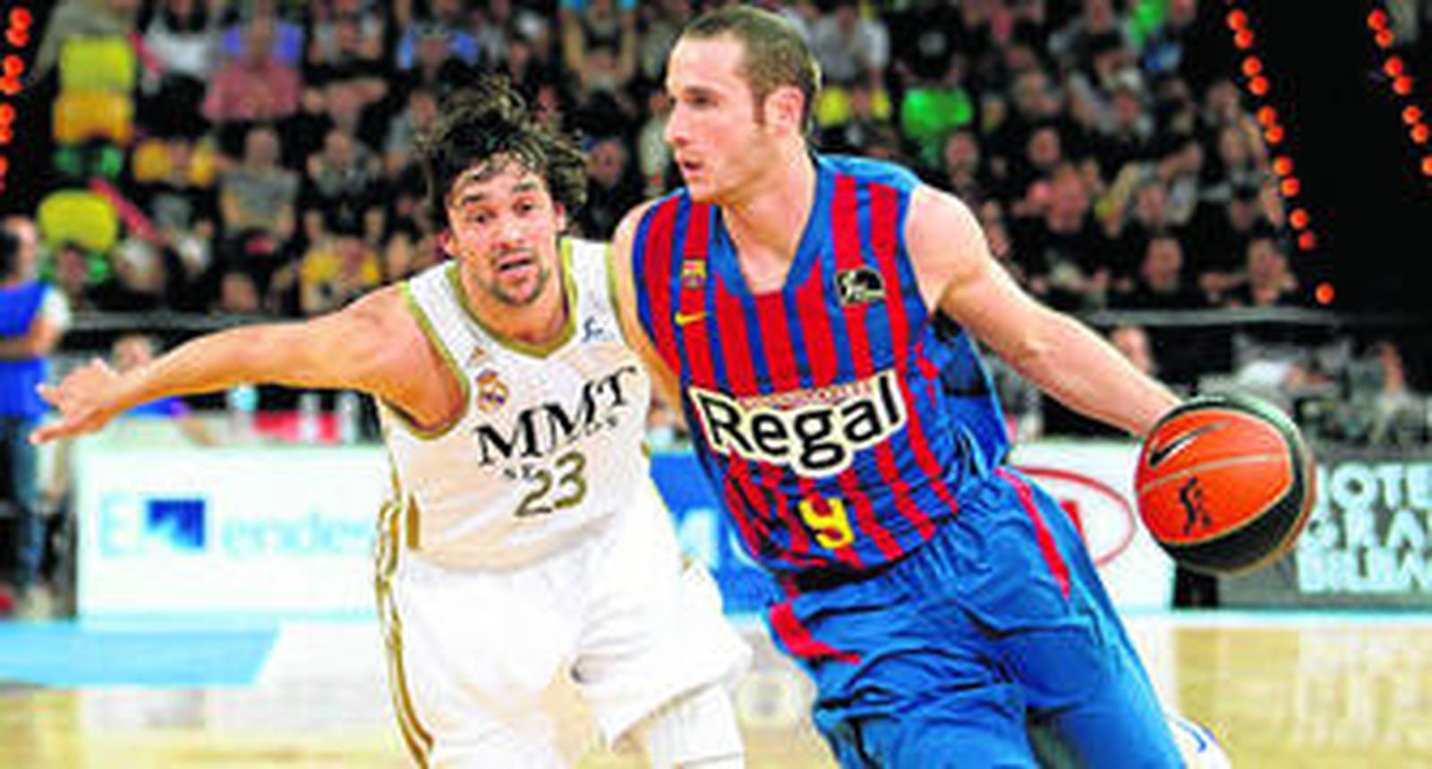 Marcelinho Huertas conduce el balón tras superar la defensa de Sergio Llull.