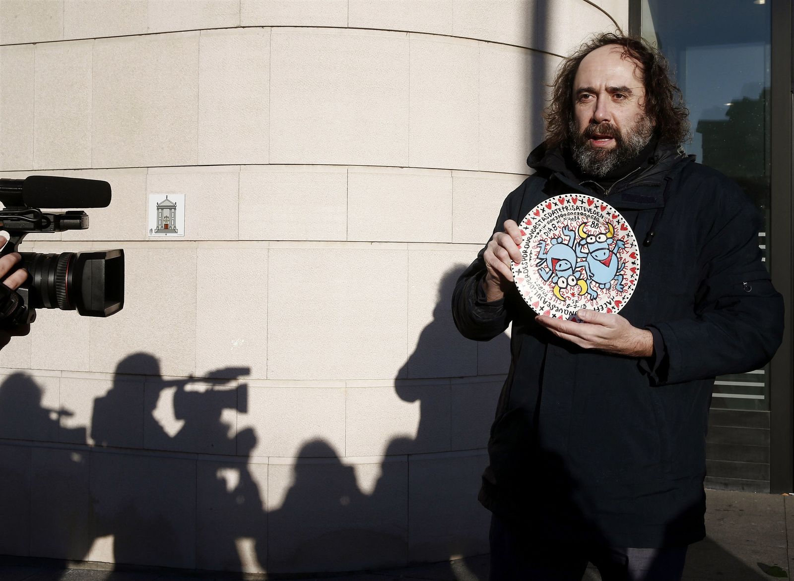 Mikel Urmeneta posa con un plato que contiene la imagen del célebre toro de Kukuxumusu.