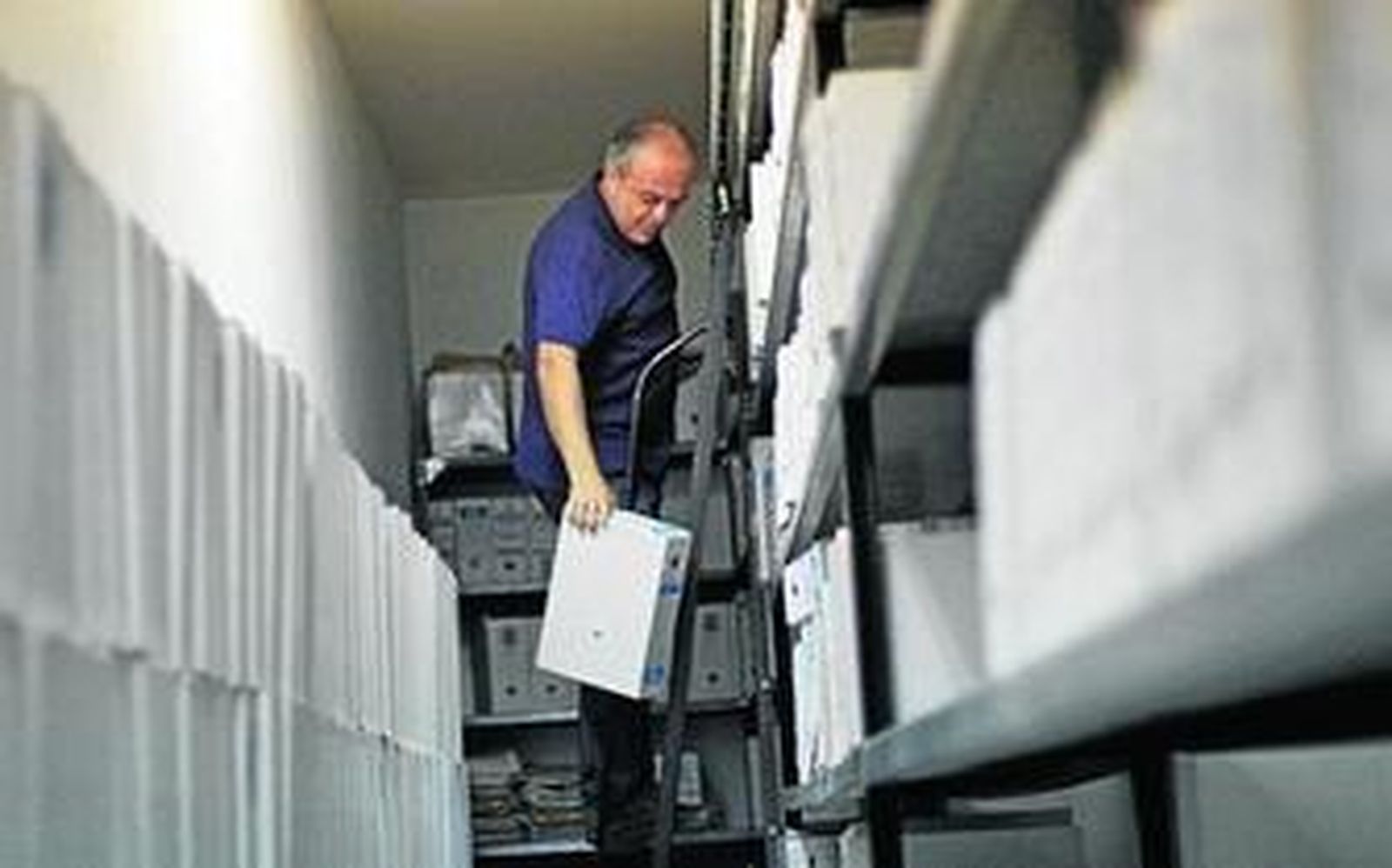 Un operario saca algunos de los archivos que van a ser eliminados.