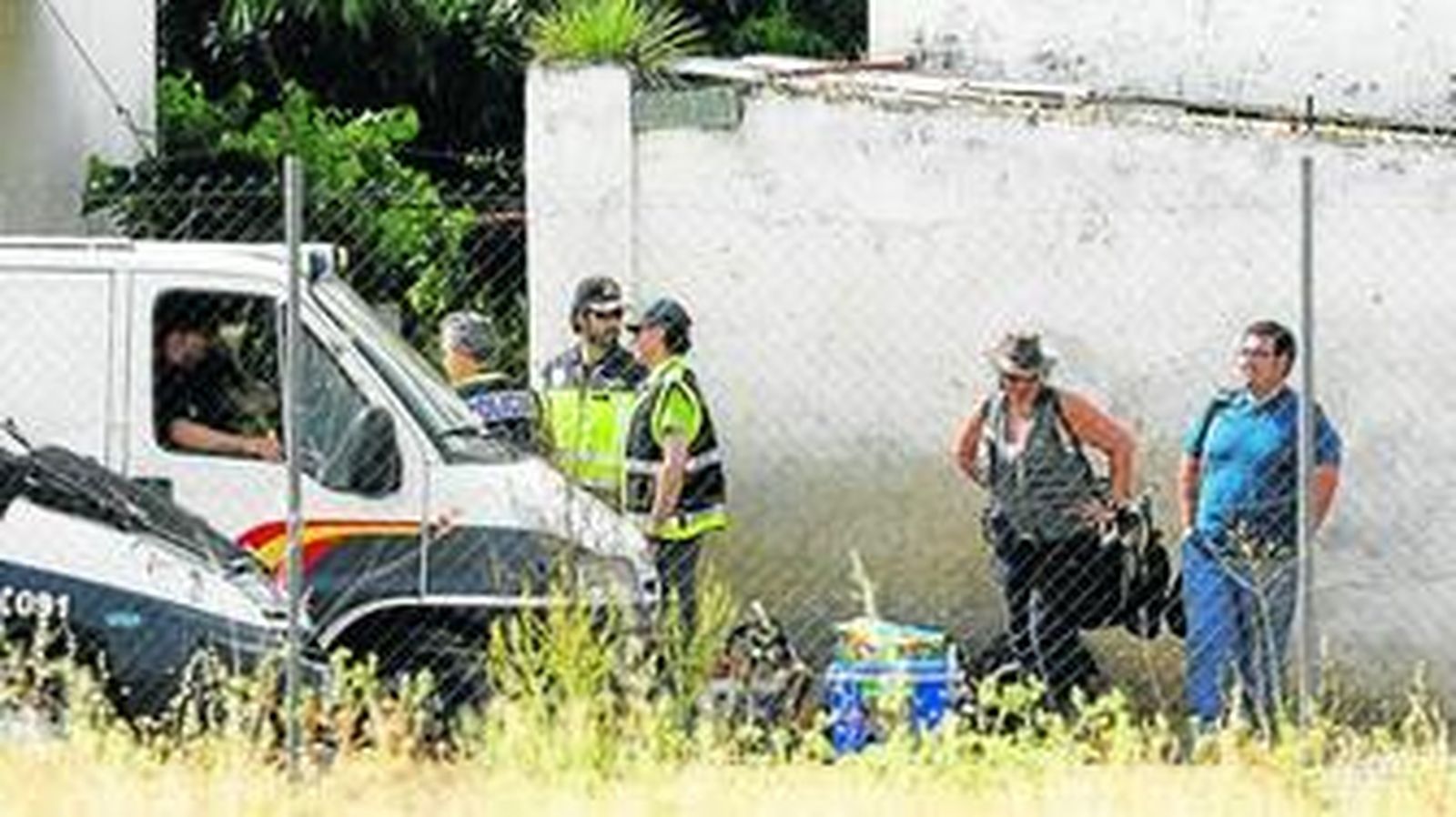 Los agentes esperan a las puertas de la parcela el comienzo de la búsqueda.