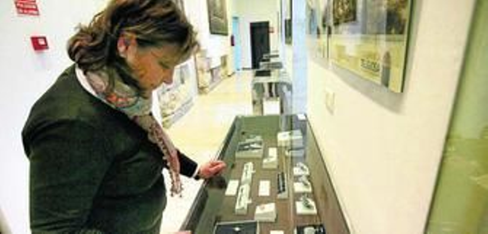 Una mujer visita una de las vitrinas con joyas de la exposición.