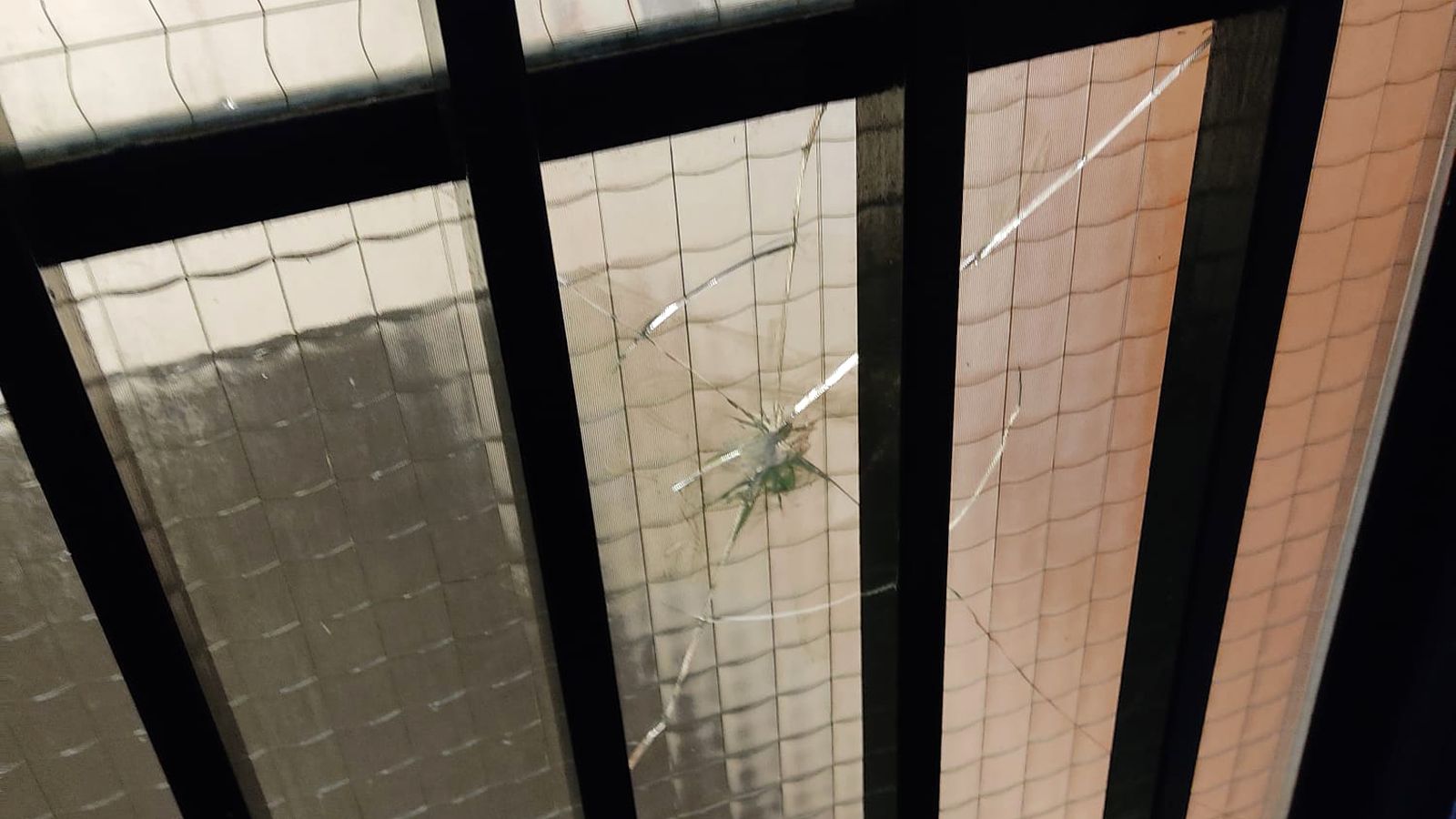 Uno de los cristales de las puertas de acceso rotos