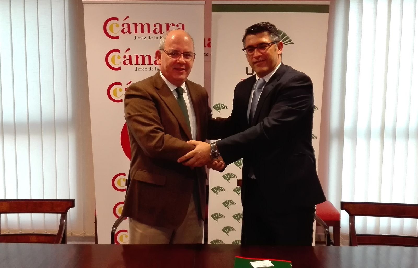 Javier Sánchez Rojas, de la Cámara de Comercio, y José Enrique Gutiérrez, de Unicaja, tras la firma.