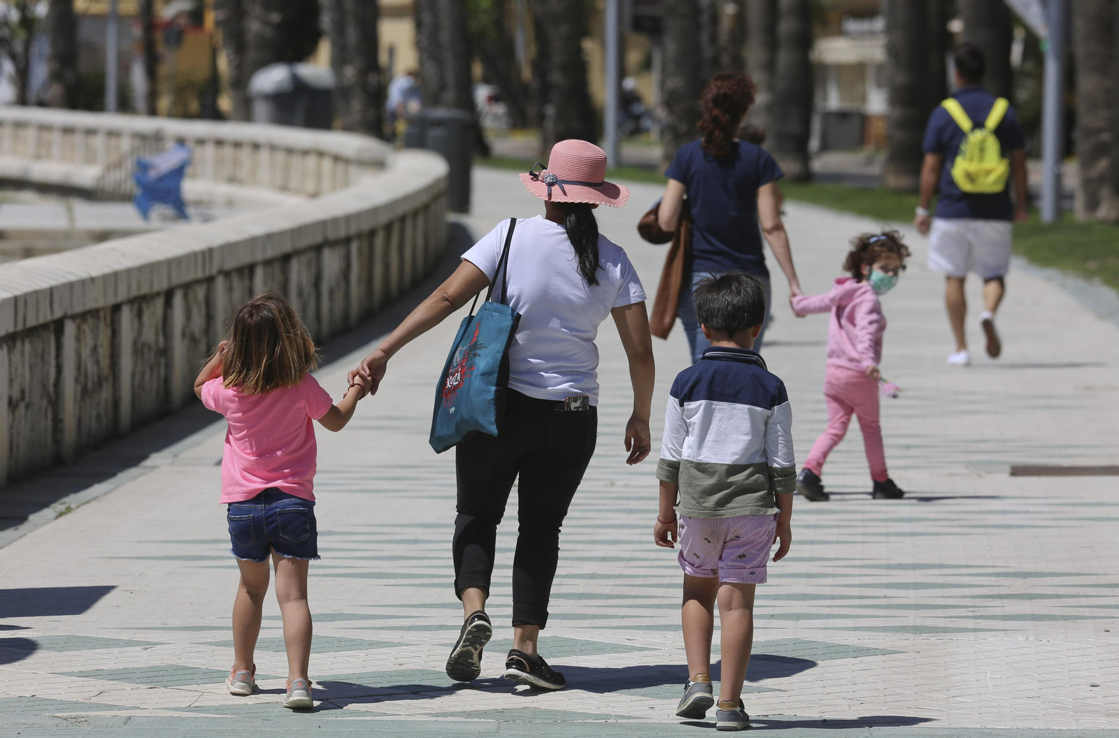 Una madre camina con sus dos hijos por el paseo marítimo Pablo Ruiz Picasso. Una madre camina con sus dos hijos por el paseo marítimo Pablo Ruiz Picasso.