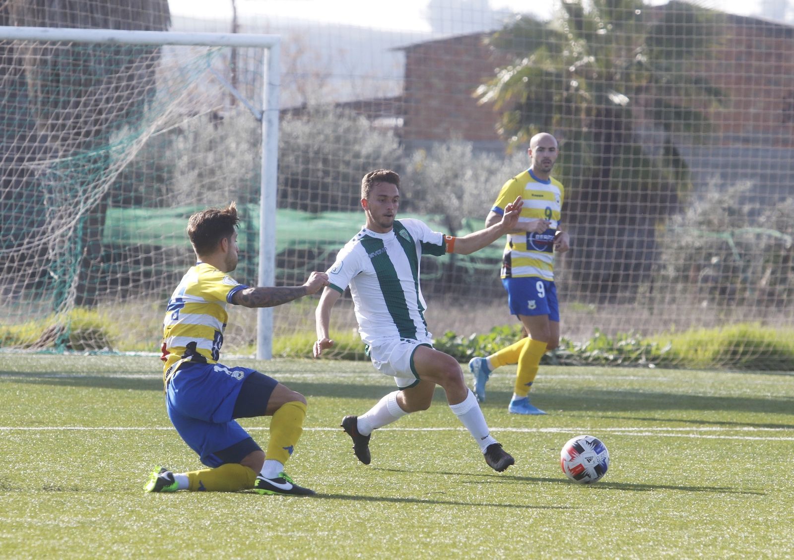Paquito, rodilla en tierra, presiona a un jugador del Córdoba.