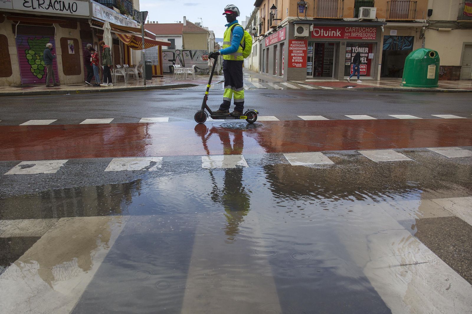 Un hombre en patinete, bajo la lluvia ayer en Málaga capital.