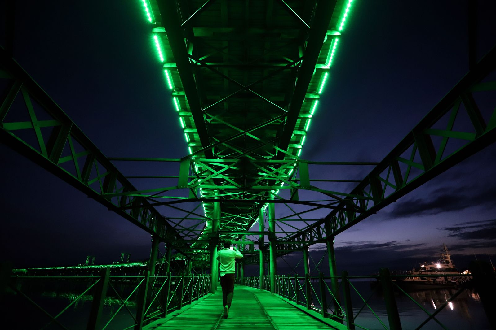 El muelle de la Riotinto se ilumina de verde en el día mundial contra el cancer