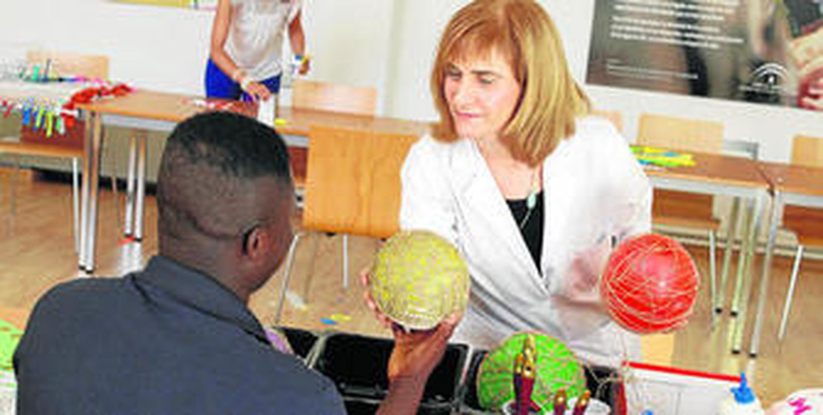 1. Un joven participa en uno de los talleres de manualidades del centro Ganivet. 2. Parte del equipo que trabaja cada día con los menores que ingresan en el centro. 3. Una monitora juega con uno de los niños al tres en raya. 4. El centro está ubicado cerca del recinto de la Alhambra. 5. Unos jóvenes se dicierten en la piscina del centro. 6. Uno de los chefs que cocina para el centro.