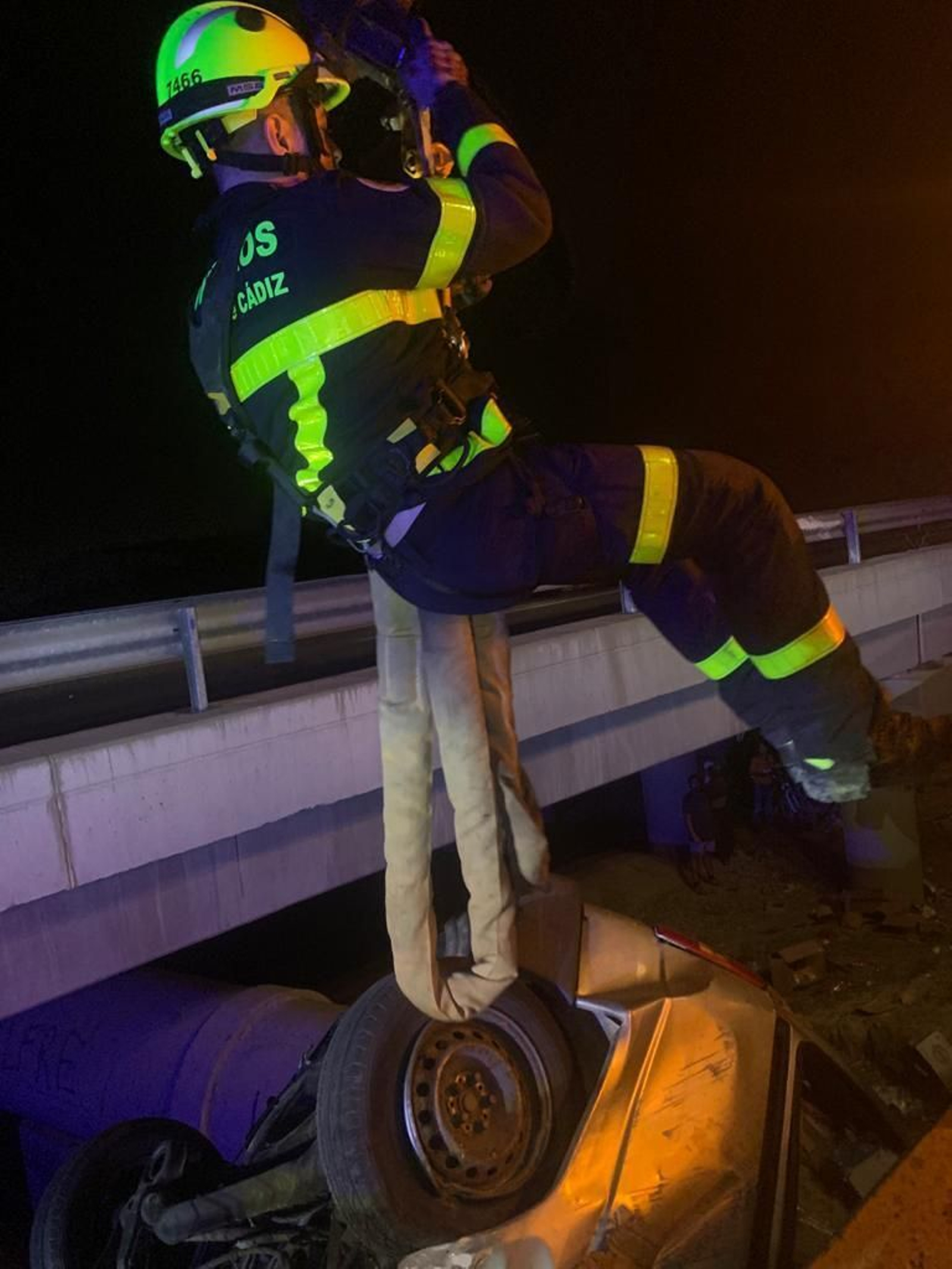 Un bombero se desliza para llegar al vehículo.