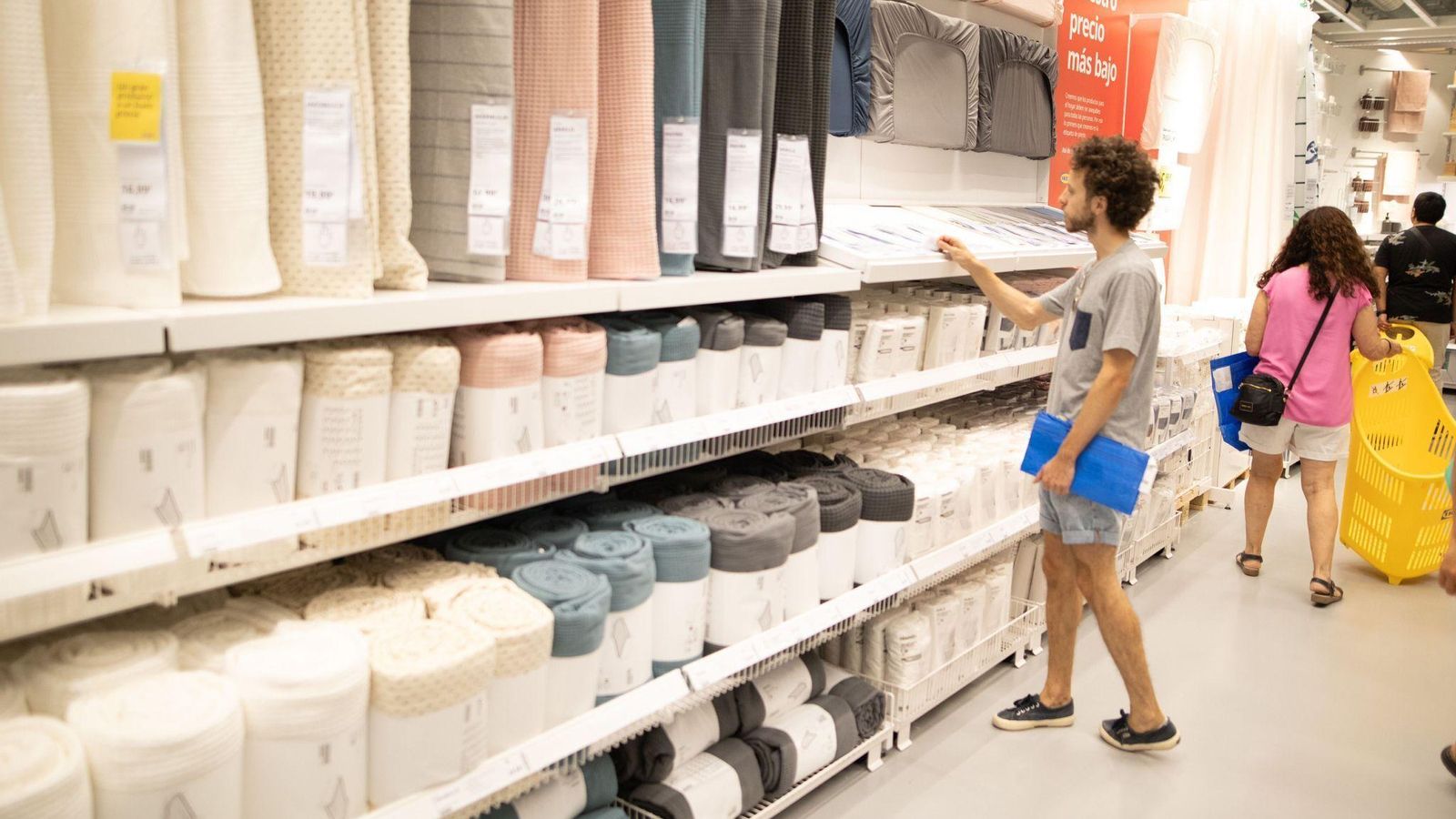 Un cliente de IKEA revisa los precios y las características de los productos textiles disponibles en tienda Un cliente de IKEA revisa los precios y las características de los productos textiles disponibles en tienda