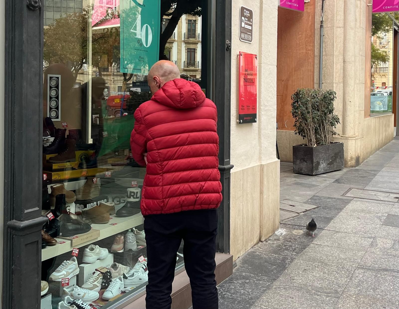 Un hombre observa los zapatos expuestos en un comercio de Almería.