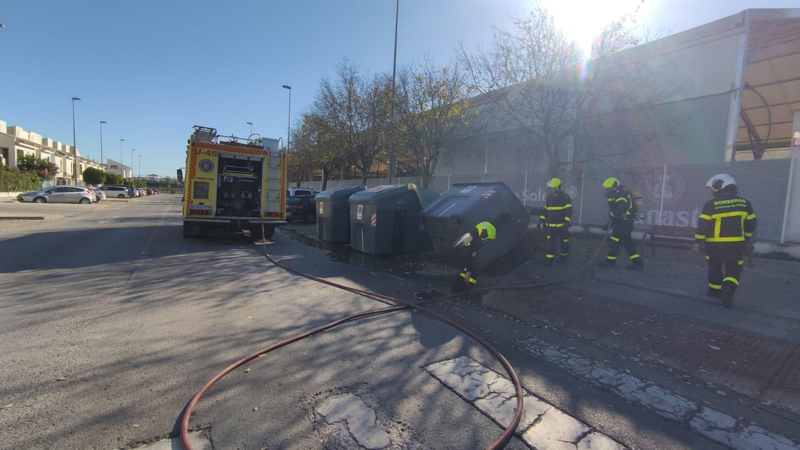Los bomberos sofocando el contenedor en la calle Concepción Arenal
