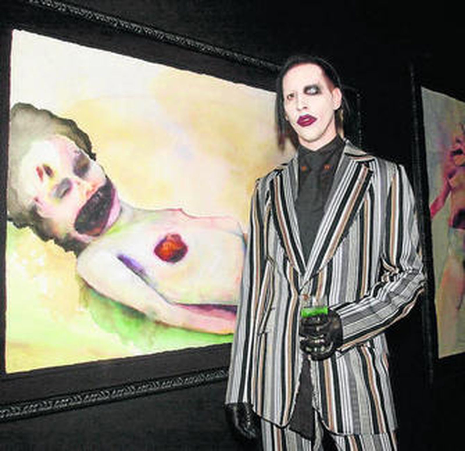 El polémico músico posa junto a uno de sus lienzos.