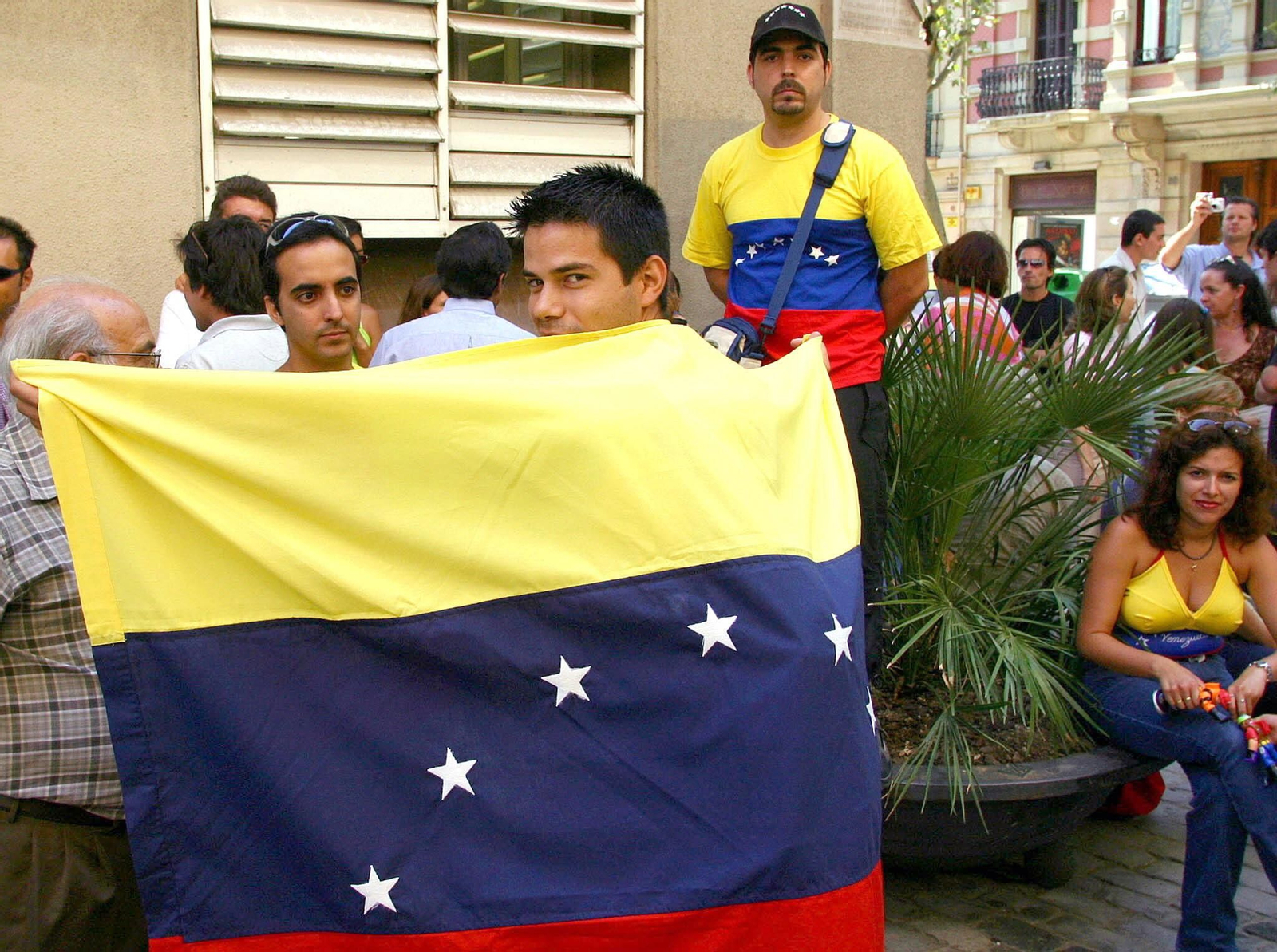 Un grupo de ciudadanos venezolanos posan junto a la bandera de Venezuela.