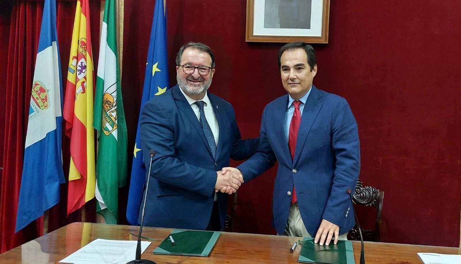 El alcalde de Carmona y el consejero de Justicia se dan la mano tras firmar el protocolo.