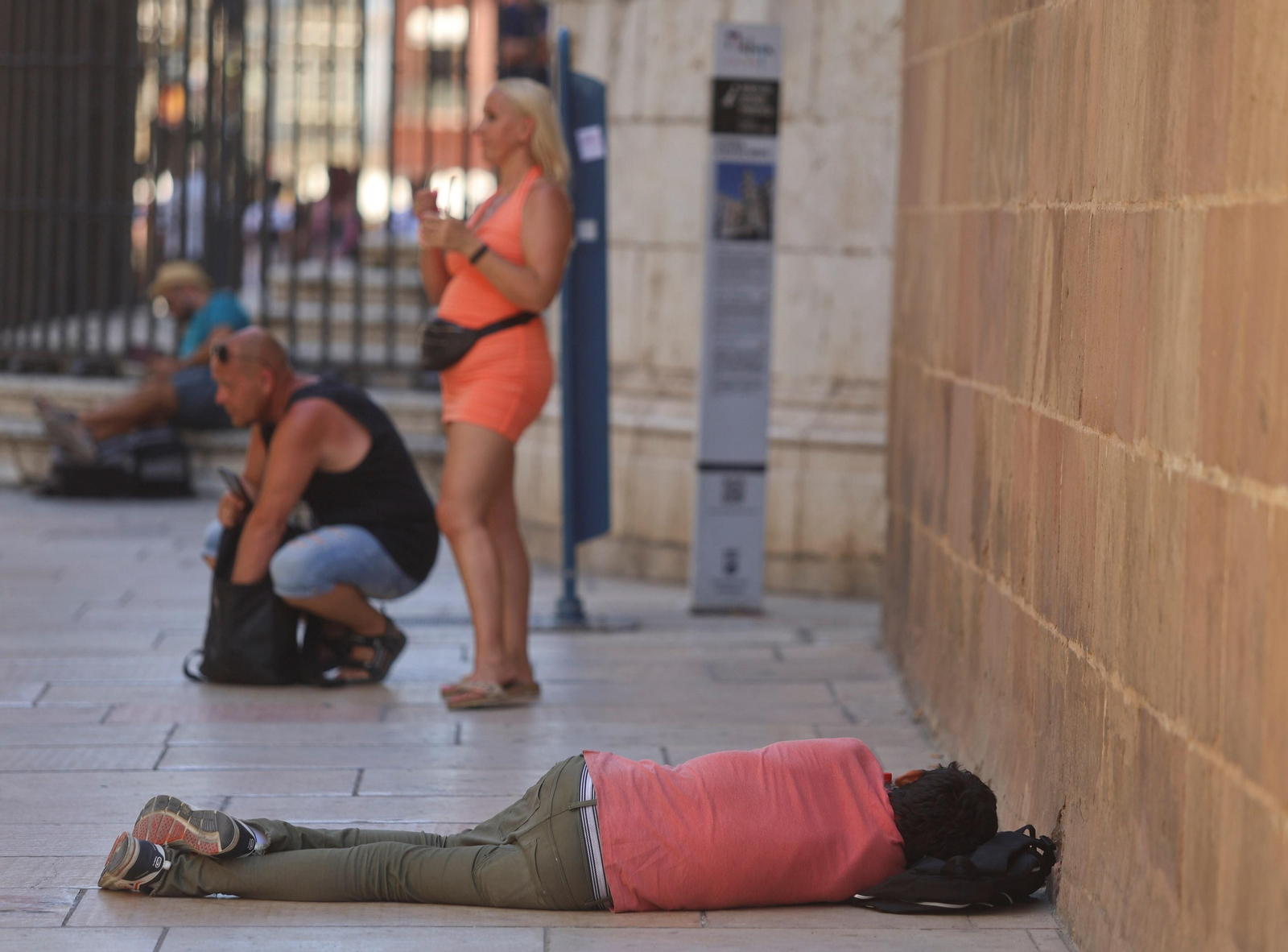 Un hombre duerme en el suelo junto a la Catedral de Málaga. Un hombre duerme en el suelo junto a la Catedral de Málaga.