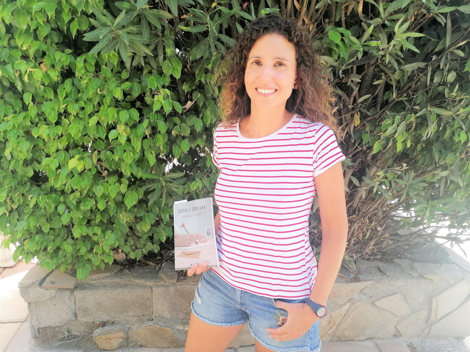 Mamen Puertas Velarde, en la Urbanización de Roquetas, con la obra que ha escrito titulada ‘Cartas a Adriana’.
