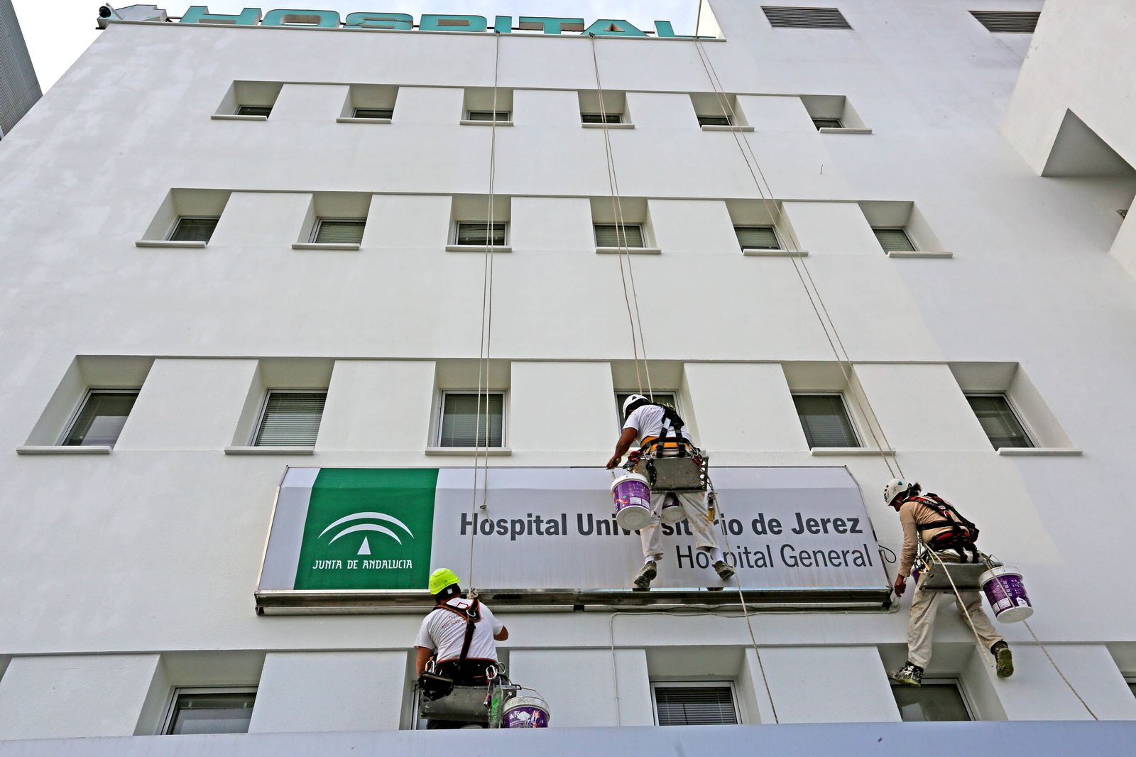 Tres operarios durante las tareas de adencetamiento de la fachada del hospital de Jerez