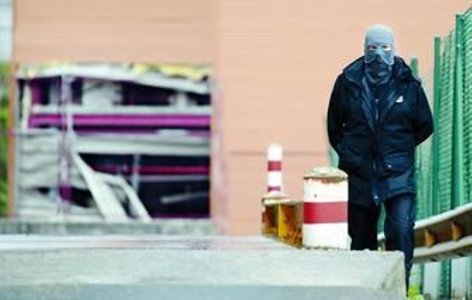 Un ertzaina comprueba los daños causados por la bomba de ETA en el exterior de las intalaciones del periódico 'El Correo' en Zamudio.